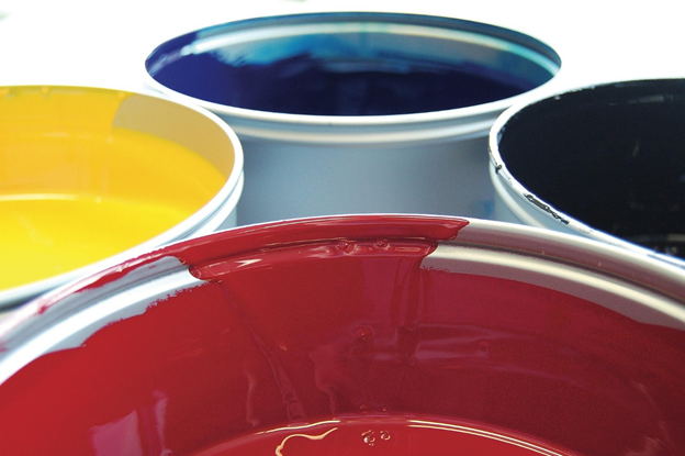 Four paint cans with vibrant colors: red, yellow, blue, and black, showcasing their glossy surfaces.